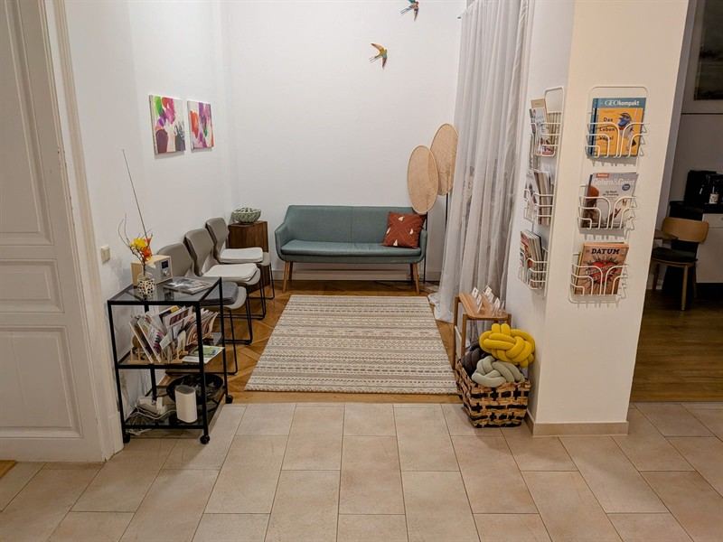 Wartebereich der Praxis Graz mit Sofa und Zeitschriften